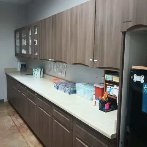 Updated pharmacy area with wooden cabinets and supplies