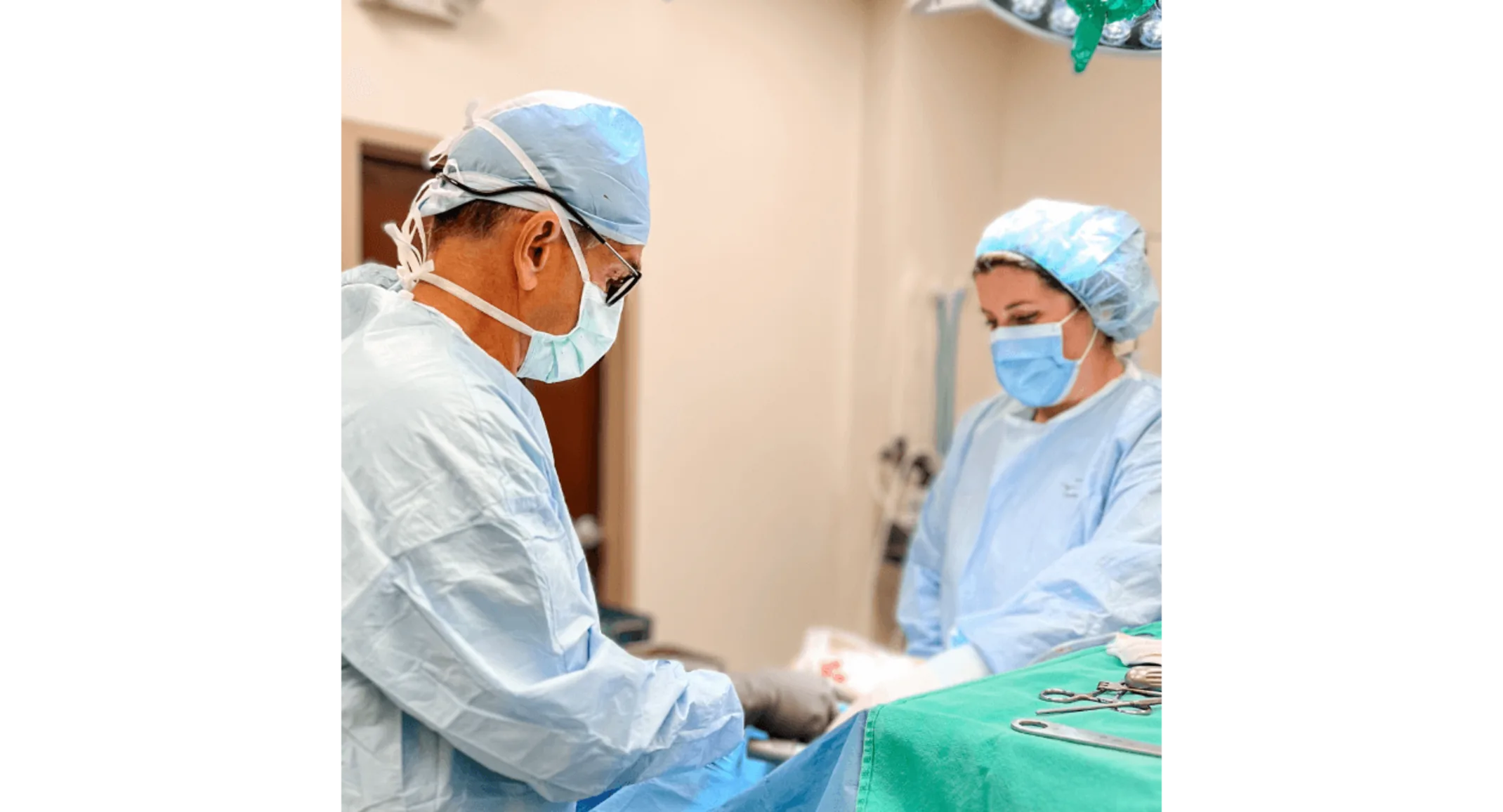 Two staff members performing surgery Two staff members performing surgery