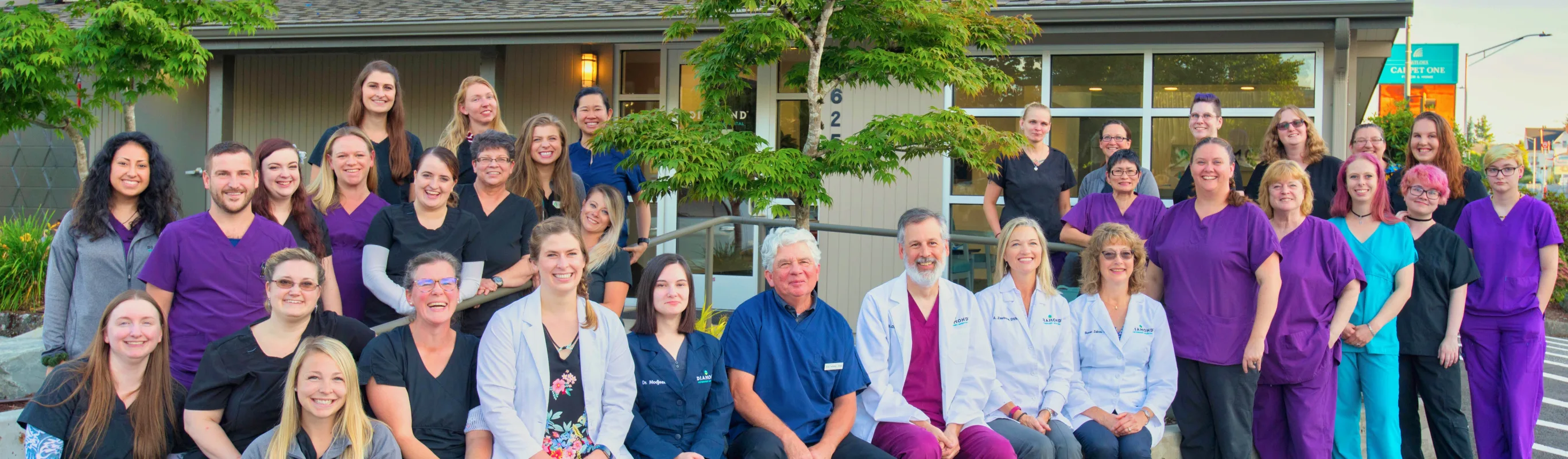 Group photo of veterinary staff in front of a hospital