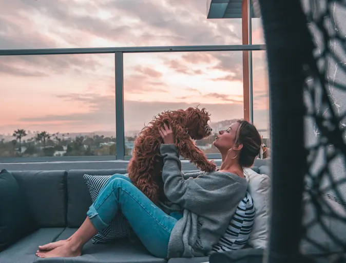woman holding dog on a balcony couch woman holding dog on a balcony couch