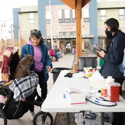 Staff with lady and dog in stroller Staff with lady and dog in stroller