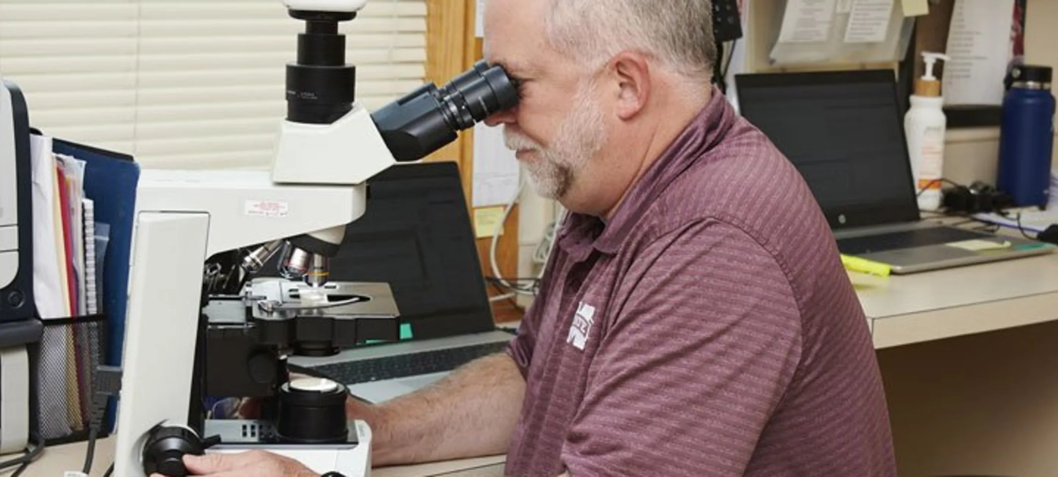 A doctor looking into a microscope