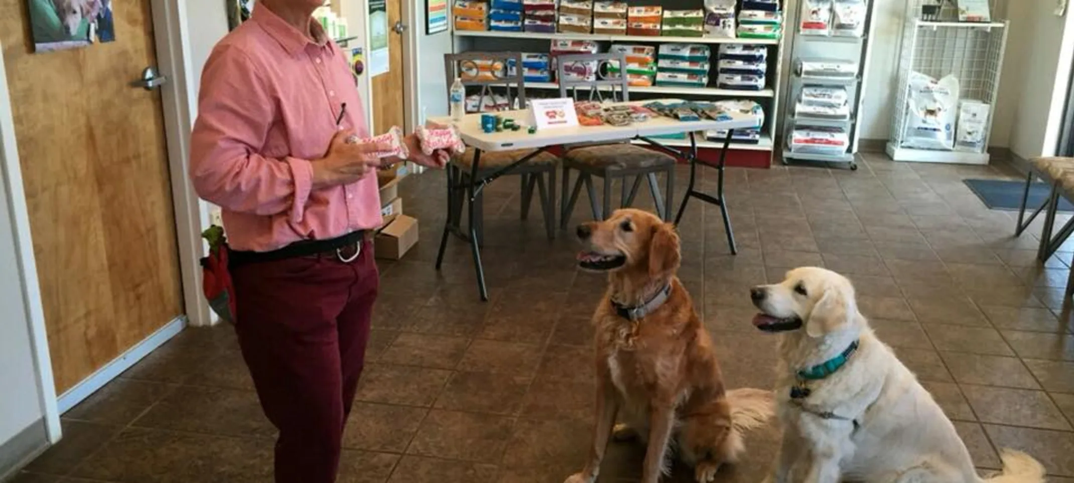 Dogs in the lobby at The Pet Ranch with staff member getting a treat
