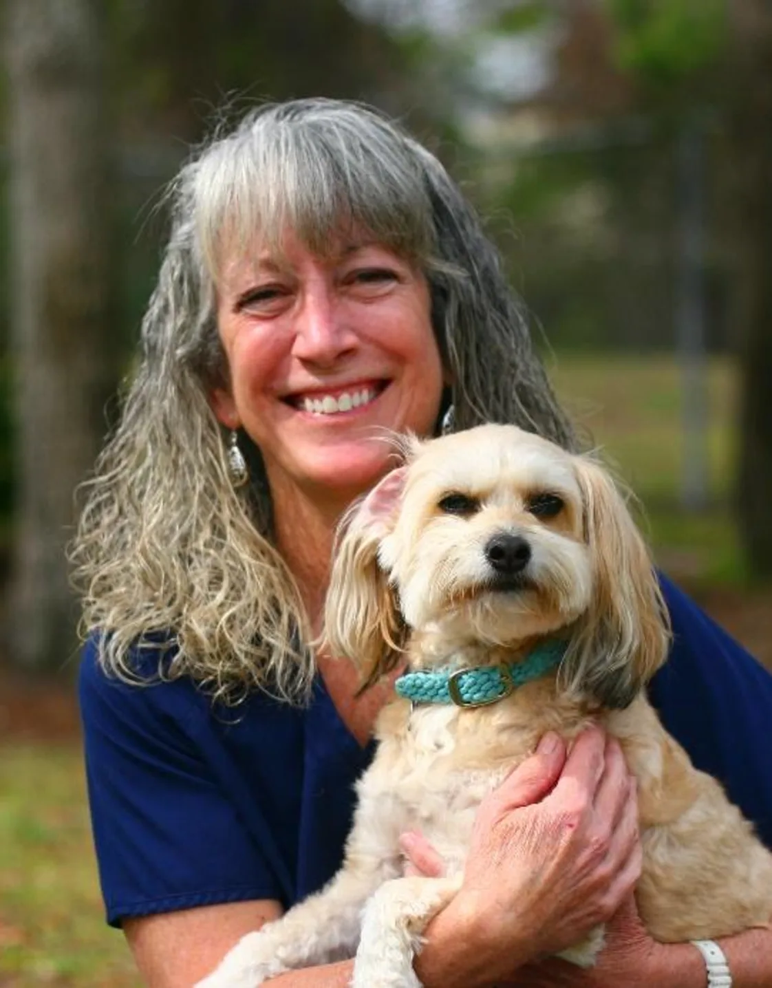 Stephanie H. holding dog outside by tree Stephanie H. holding dog outside by tree