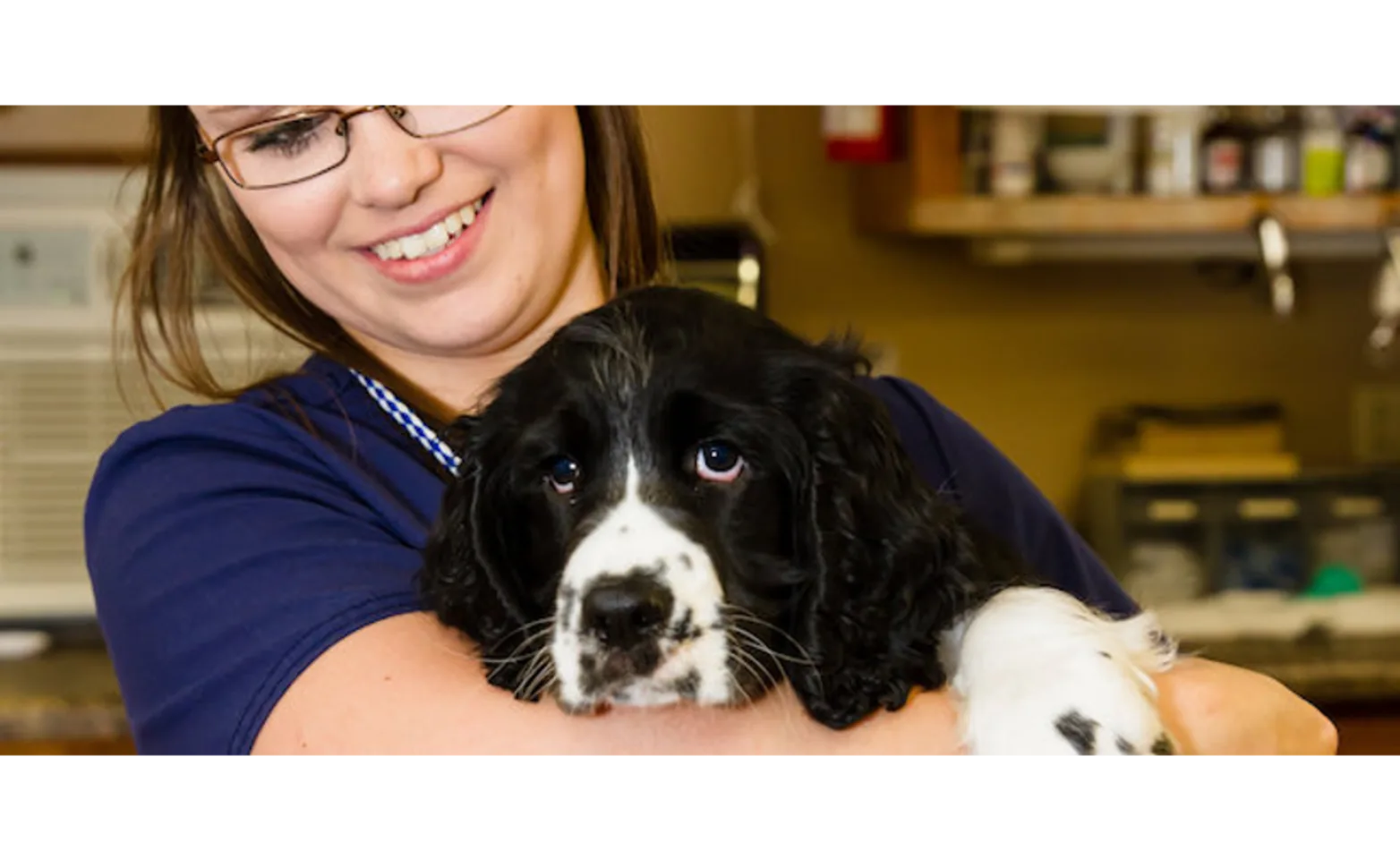 Women holding a black dog 