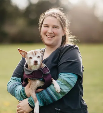 Tess Schrenk holding a small dog outdoors