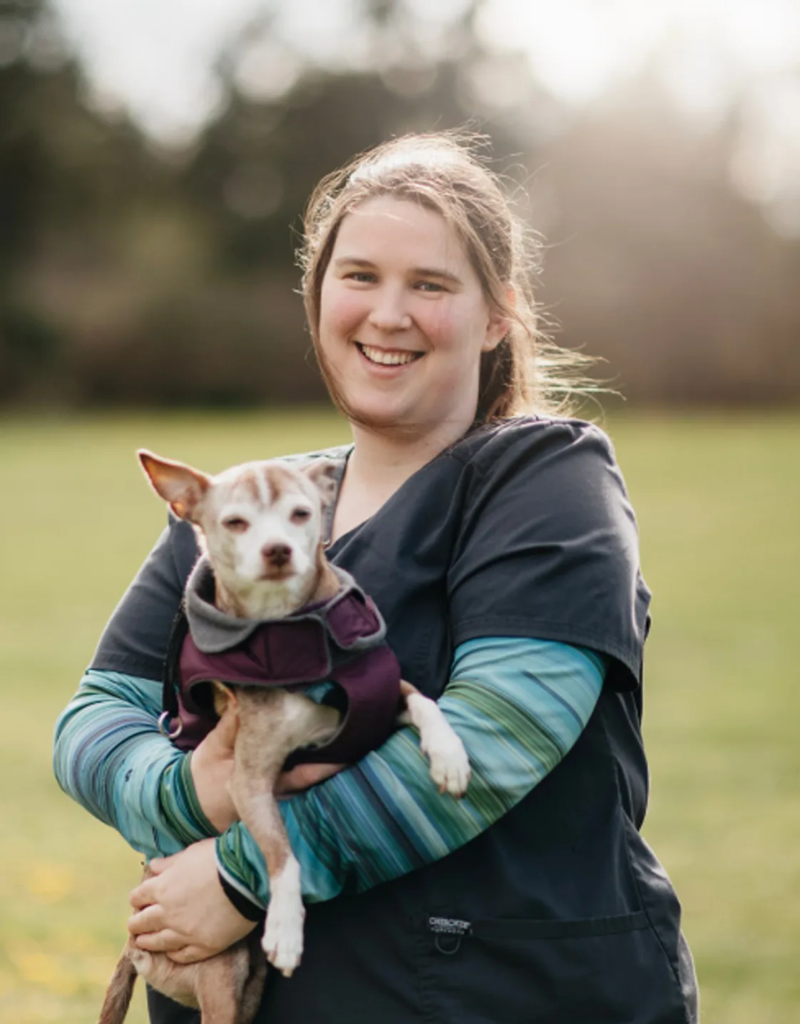 Tess Schrenk holding a small dog outdoors Tess Schrenk holding a small dog outdoors
