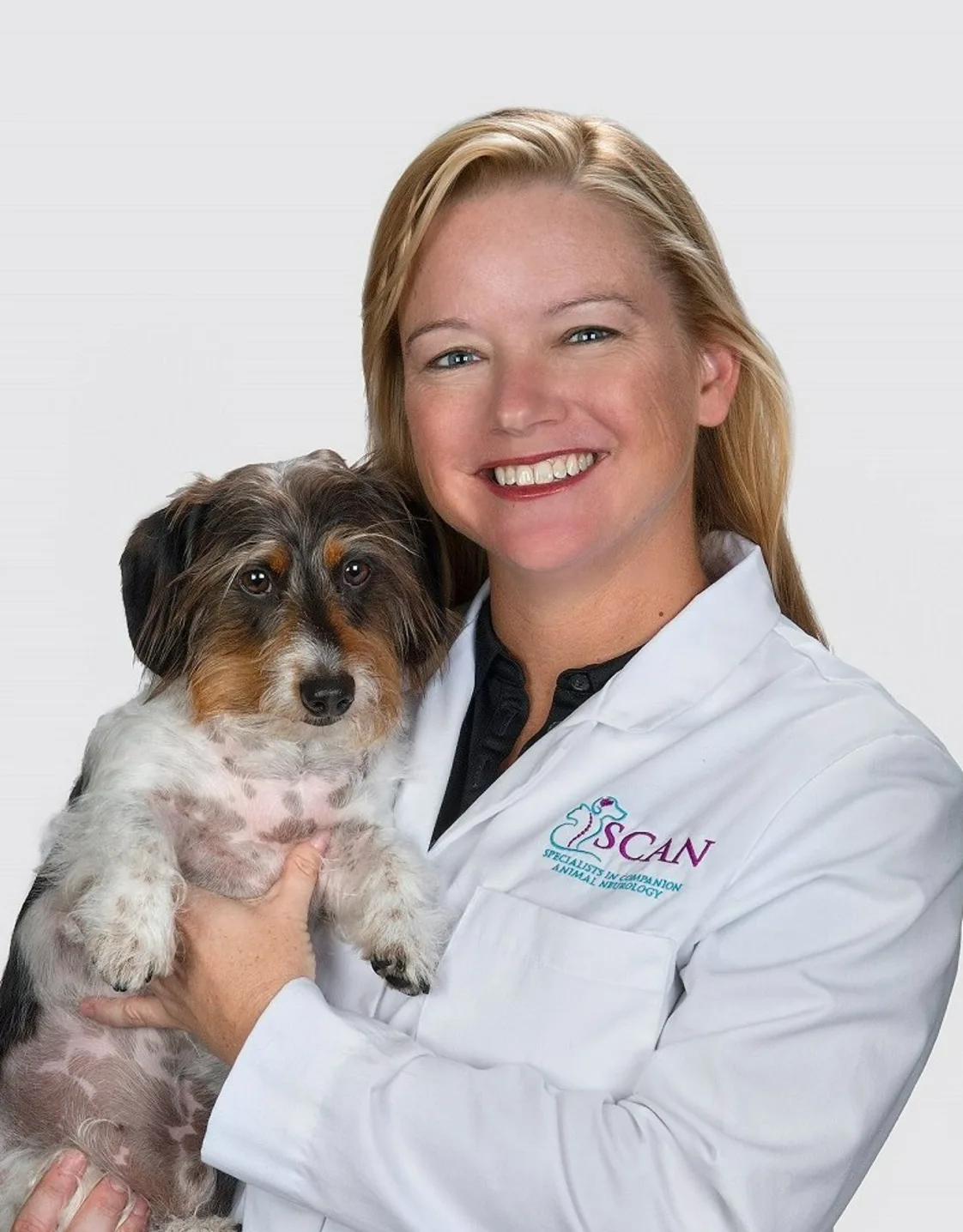 Dr. Carnes holding a scruffy dog Dr. Carnes holding a scruffy dog