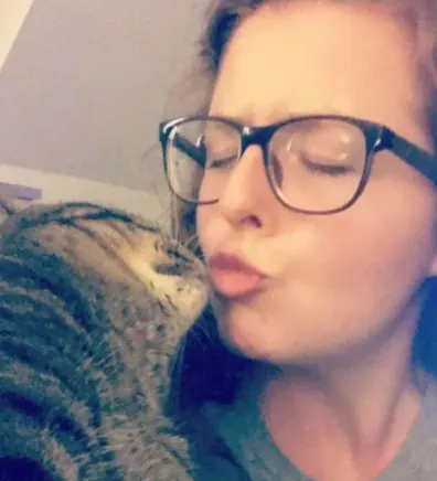 Morgan Ellis kissing a cat