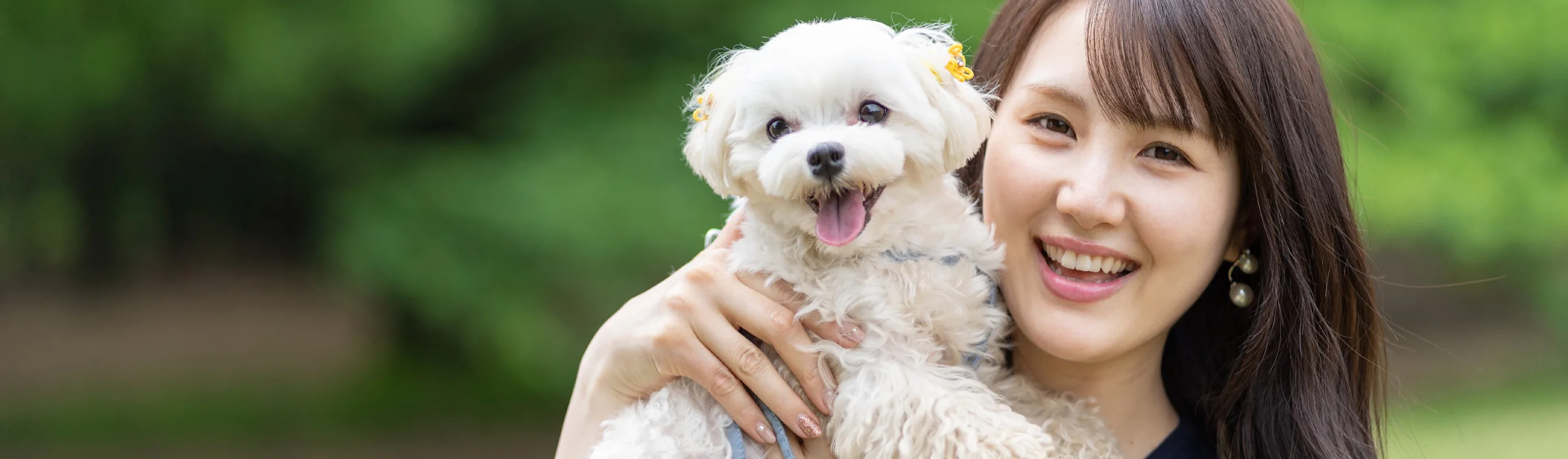 Woman holding up a white dog