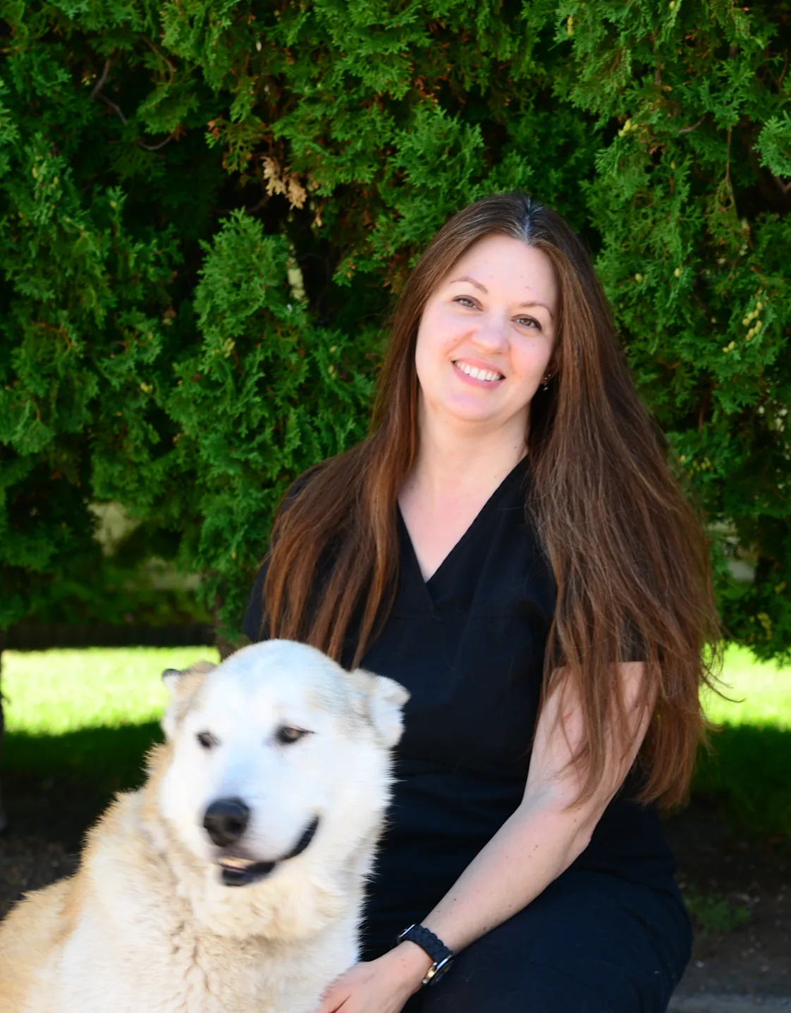 Becky holding a dog and sitting in front of the Eastside sign Becky holding a dog and sitting in front of the Eastside sign