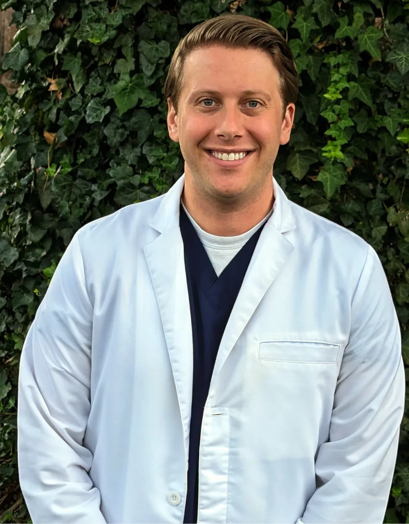 Dr. Kussin's staff photo from Foothills Veterinary Hospital where he is standing outside wearing his light blur scrubs.