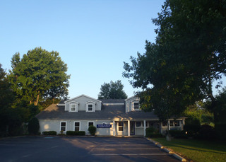 Poquoson Veterinary Hospital Front Exterior of the building with a nice clean cut lawn and lush trees surrounding it.