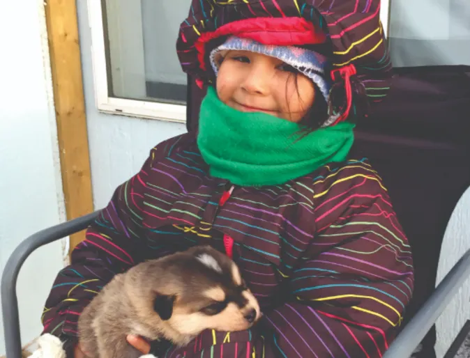 a sitting child holding a ferret a sitting child holding a ferret