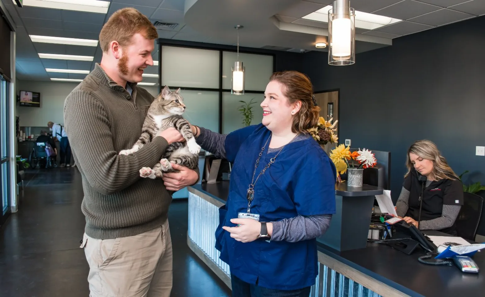 Veterinary staff with client and patient cat. Veterinary staff with client and patient cat.