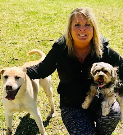 Lynn's staff photo from Stillwater Veterinary Clinic and her black and white dog posing outside. Lynn's staff photo from Stillwater Veterinary Clinic and her black and white dog posing outside.