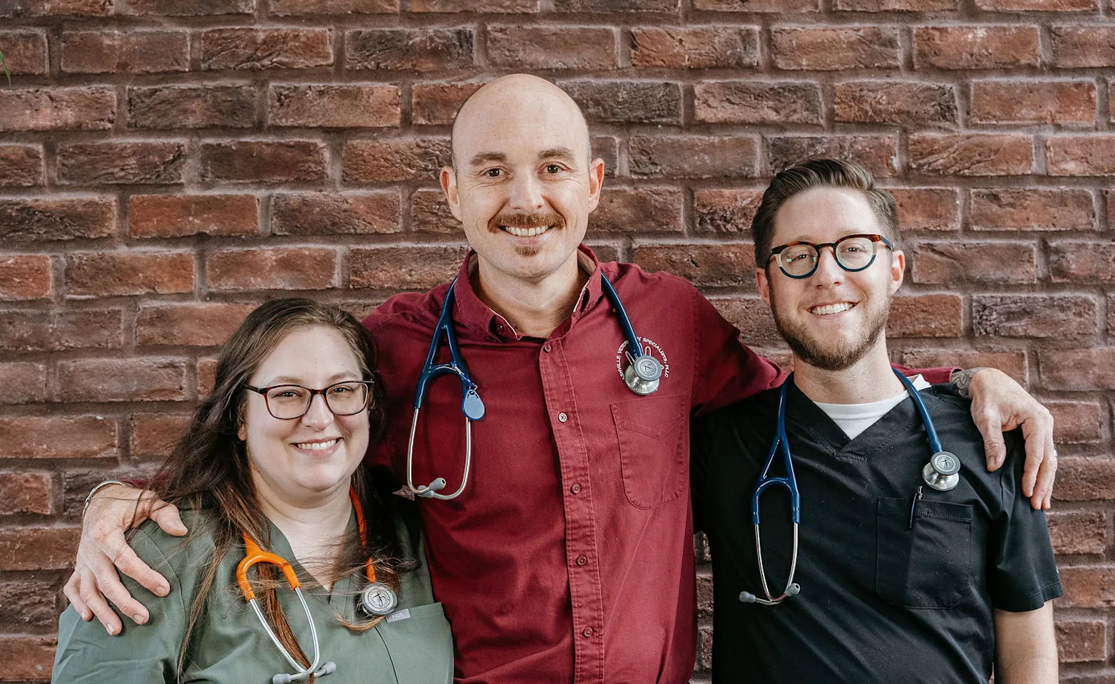 three staff members simling at camera