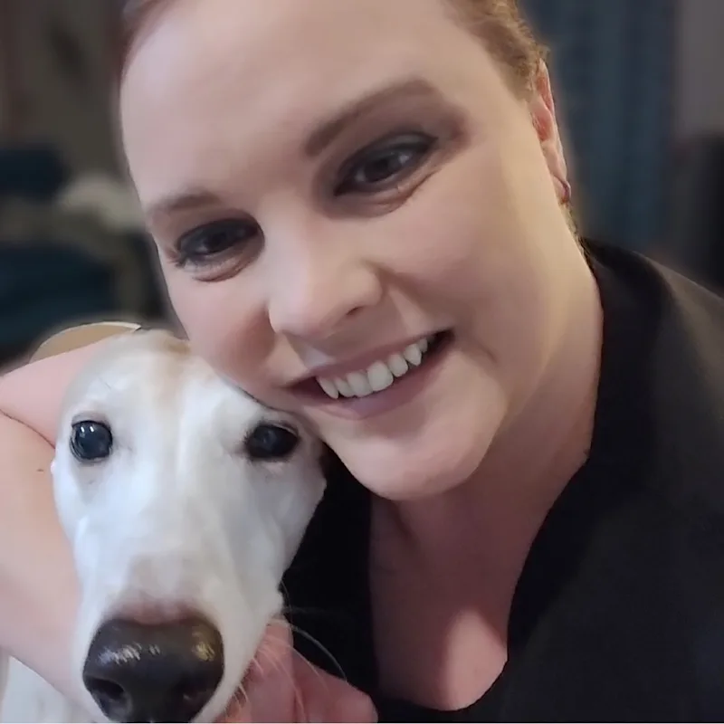Jennifer smiling, hugging a large white dog Jennifer smiling, hugging a large white dog
