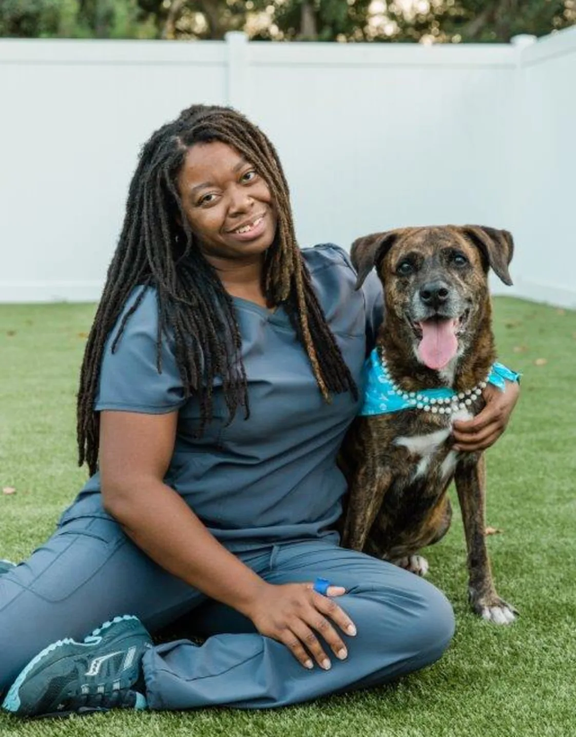 Robin Robinson with brown dog wearing blue bandana Robin Robinson with brown dog wearing blue bandana