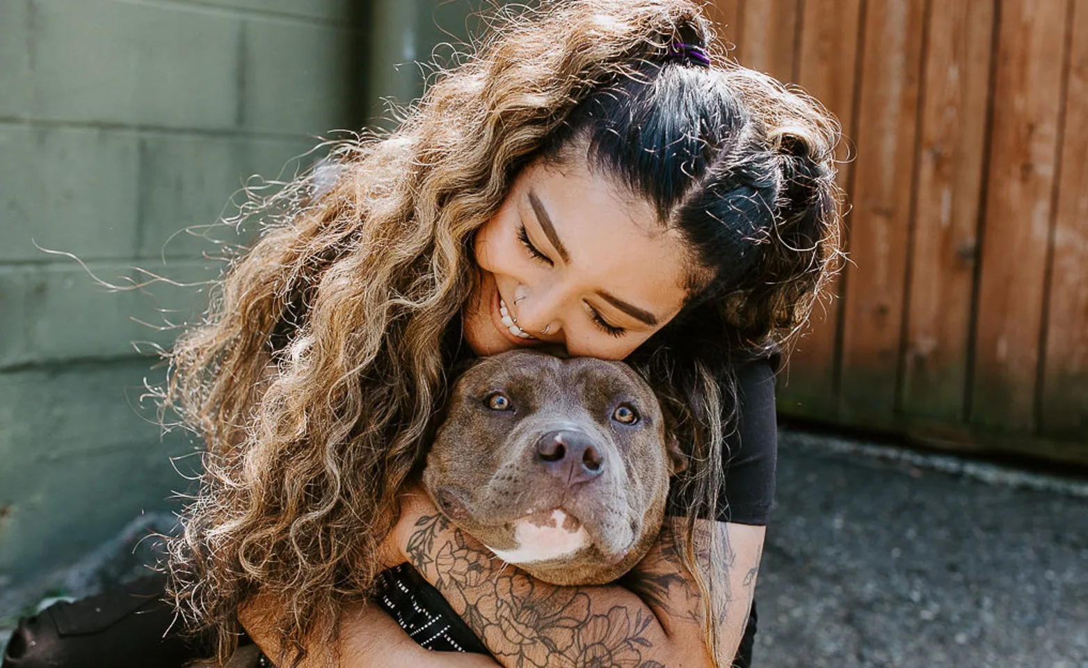 A veterinary technician hugging a brown dog A veterinary technician hugging a brown dog