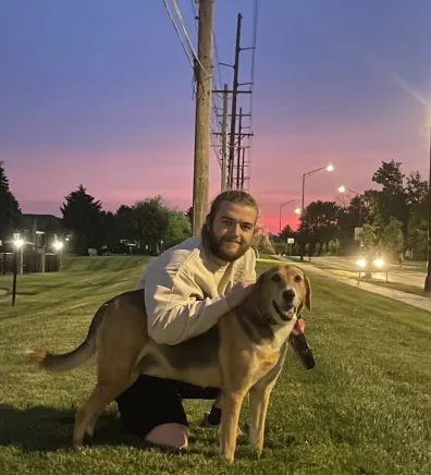 Blake, groomer at PetSuites Worthington, with a dog