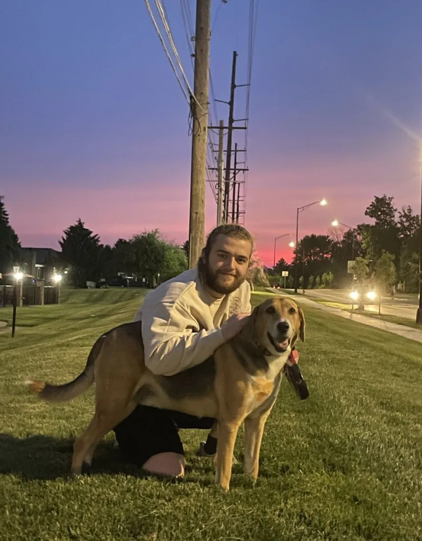 Blake, groomer at PetSuites Worthington, with a dog