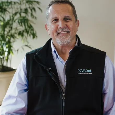 Dr. Hill wearing black vest with NVA logo