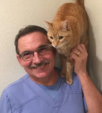 Doug with an orange cat standing on his shoulder