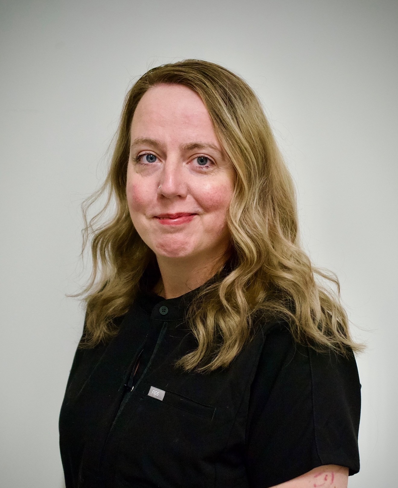 Holly Norris headshot, smiling in a black shirt