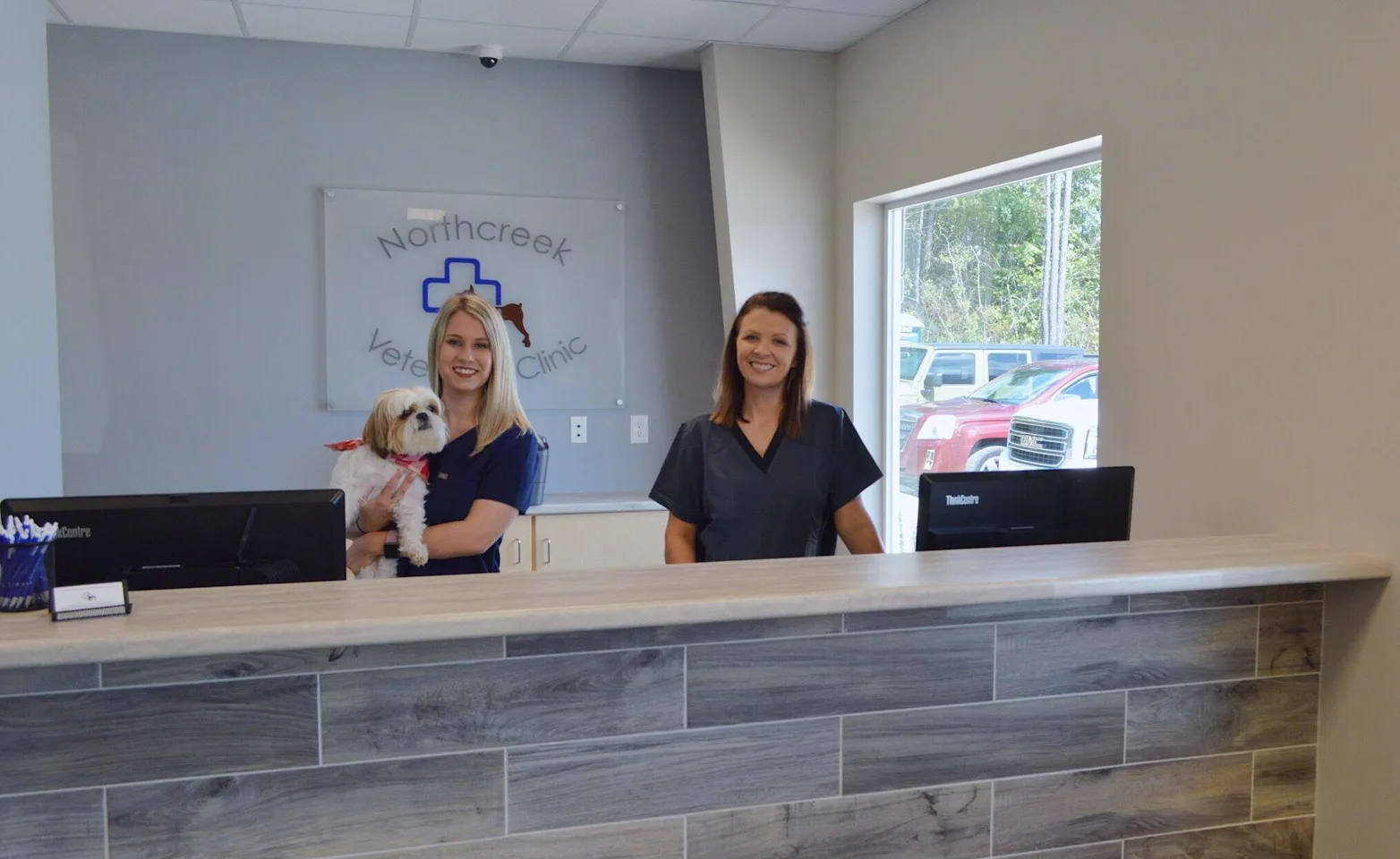 Two staff standing at the welcome desk at Northcreek Veterinary Clinic Two staff standing at the welcome desk at Northcreek Veterinary Clinic