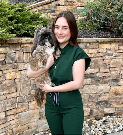 A veterinarian posing with a dog A veterinarian posing with a dog