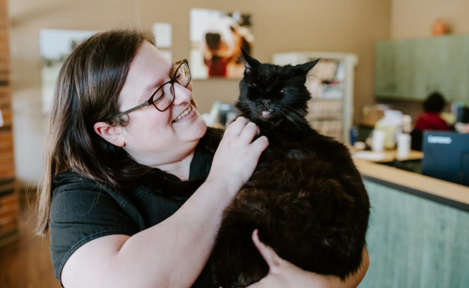 Staff with smiling black cat at Arroyo Vista Veterinary Hospital Staff with smiling black cat at Arroyo Vista Veterinary Hospital