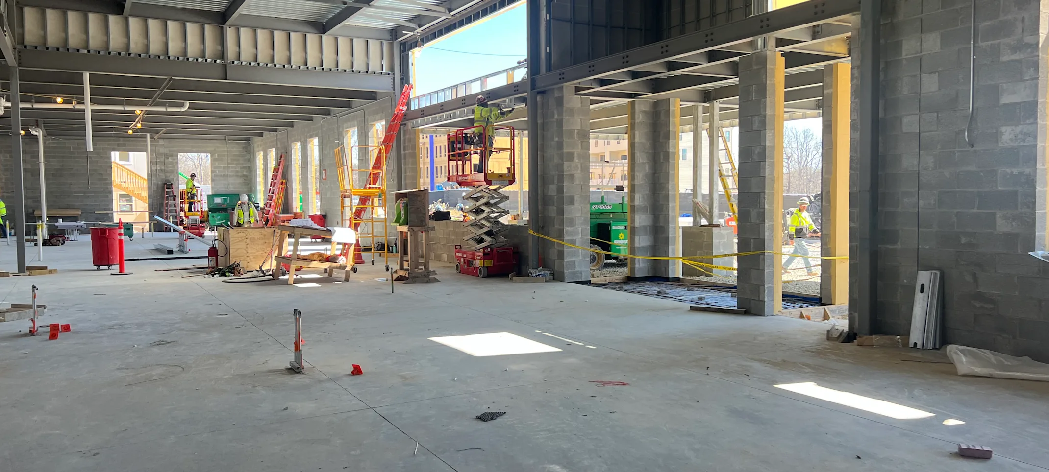 An empty room with the ceiling and walls under construction by workers An empty room with the ceiling and walls under construction by workers