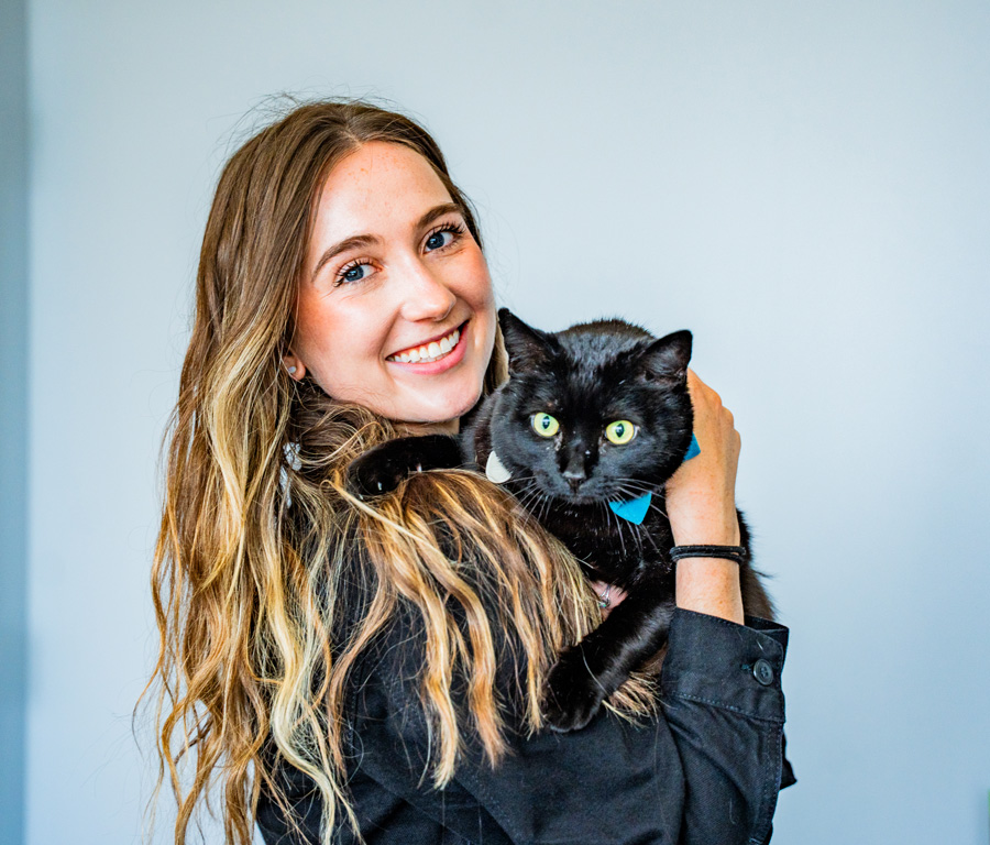 girl holding black cat and smiling
