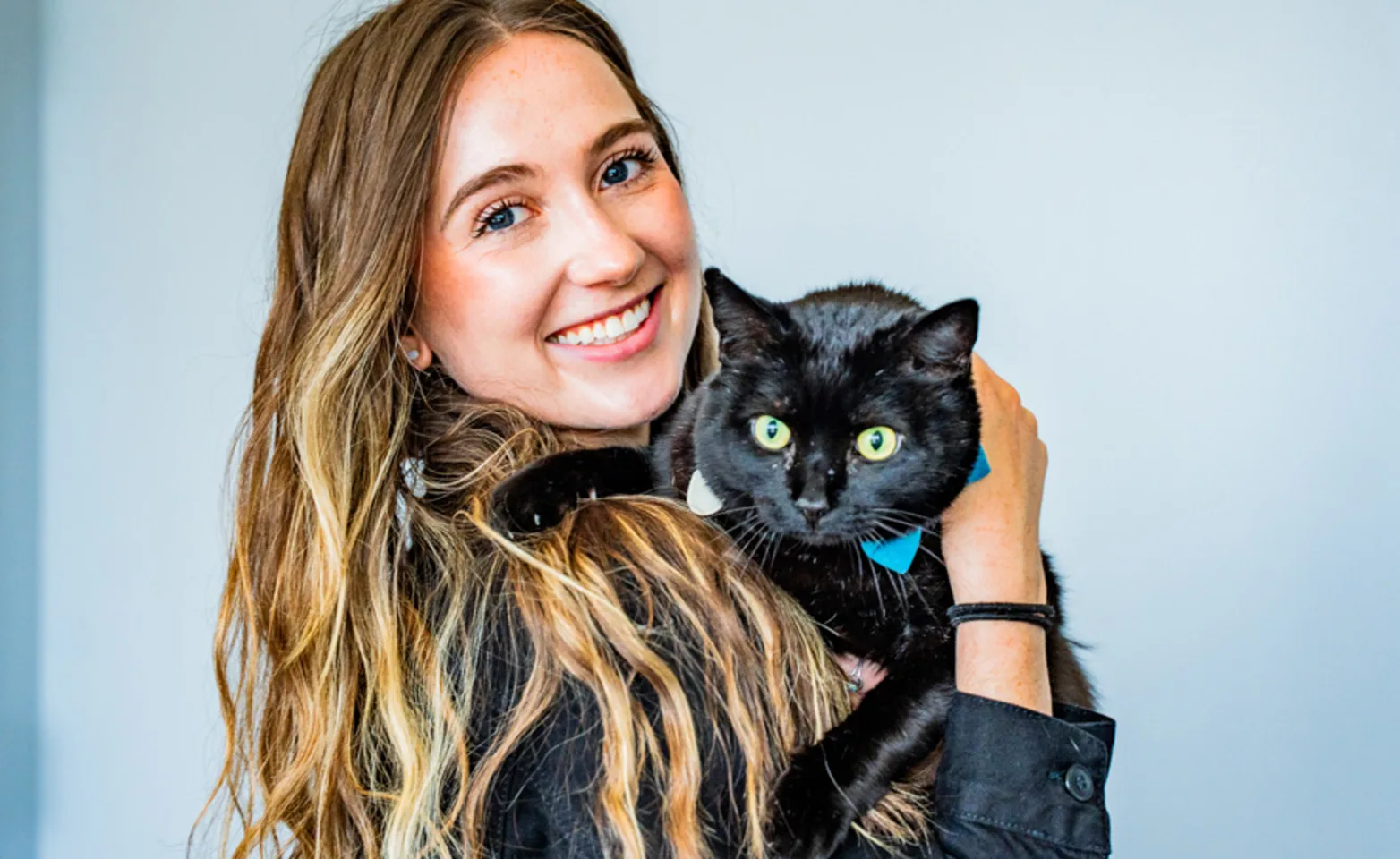 girl holding black cat and smiling girl holding black cat and smiling