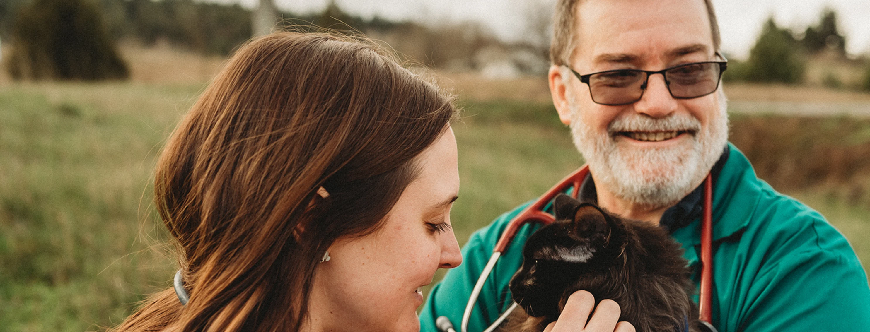 Two people holding a cat