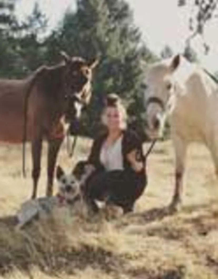 Taylor Scott kneeling next to two horses