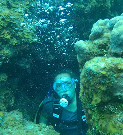 Kristen Roberts diving between corals Kristen Roberts diving between corals