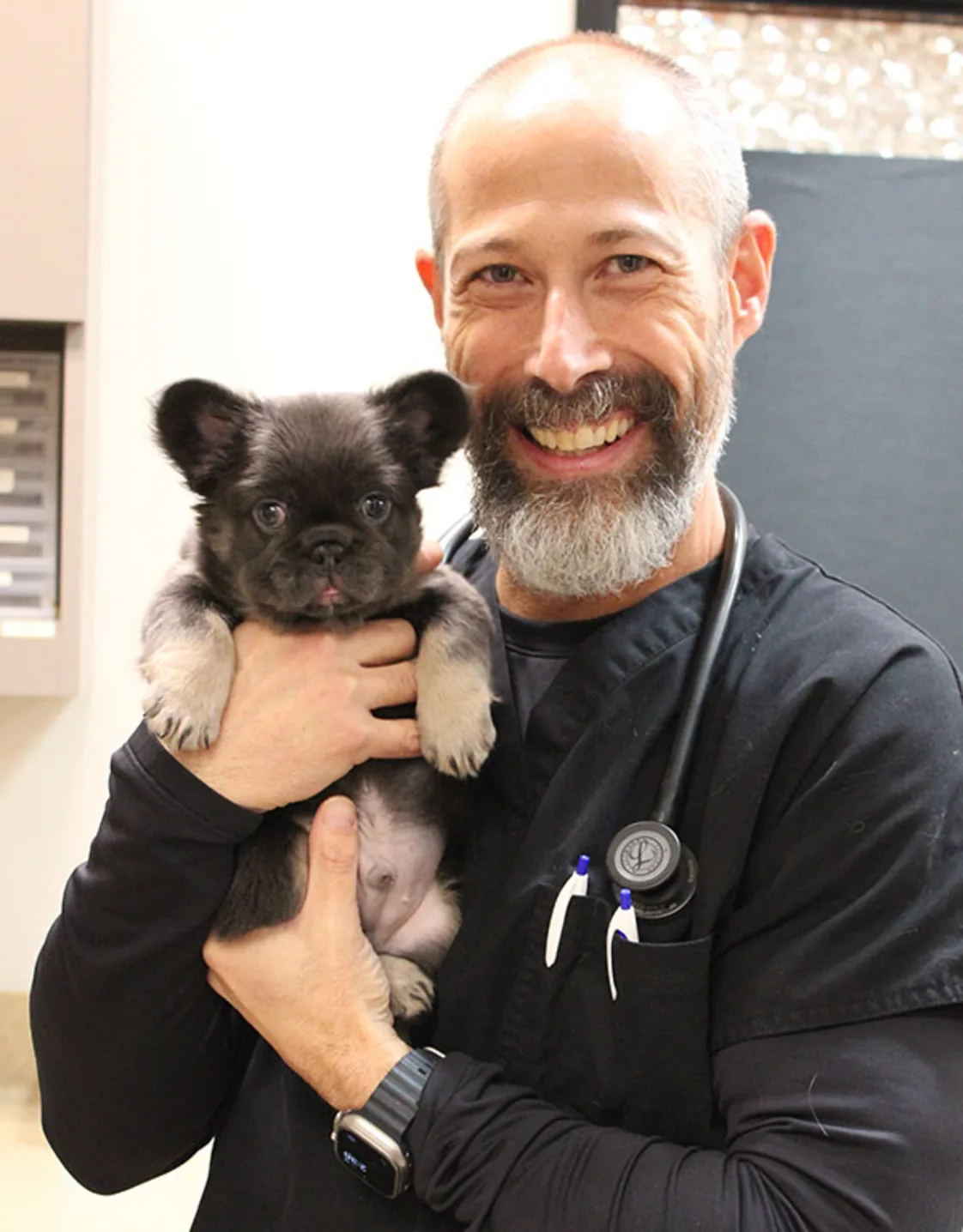 Dr. Eric Kane holding a dog in office Dr. Eric Kane holding a dog in office