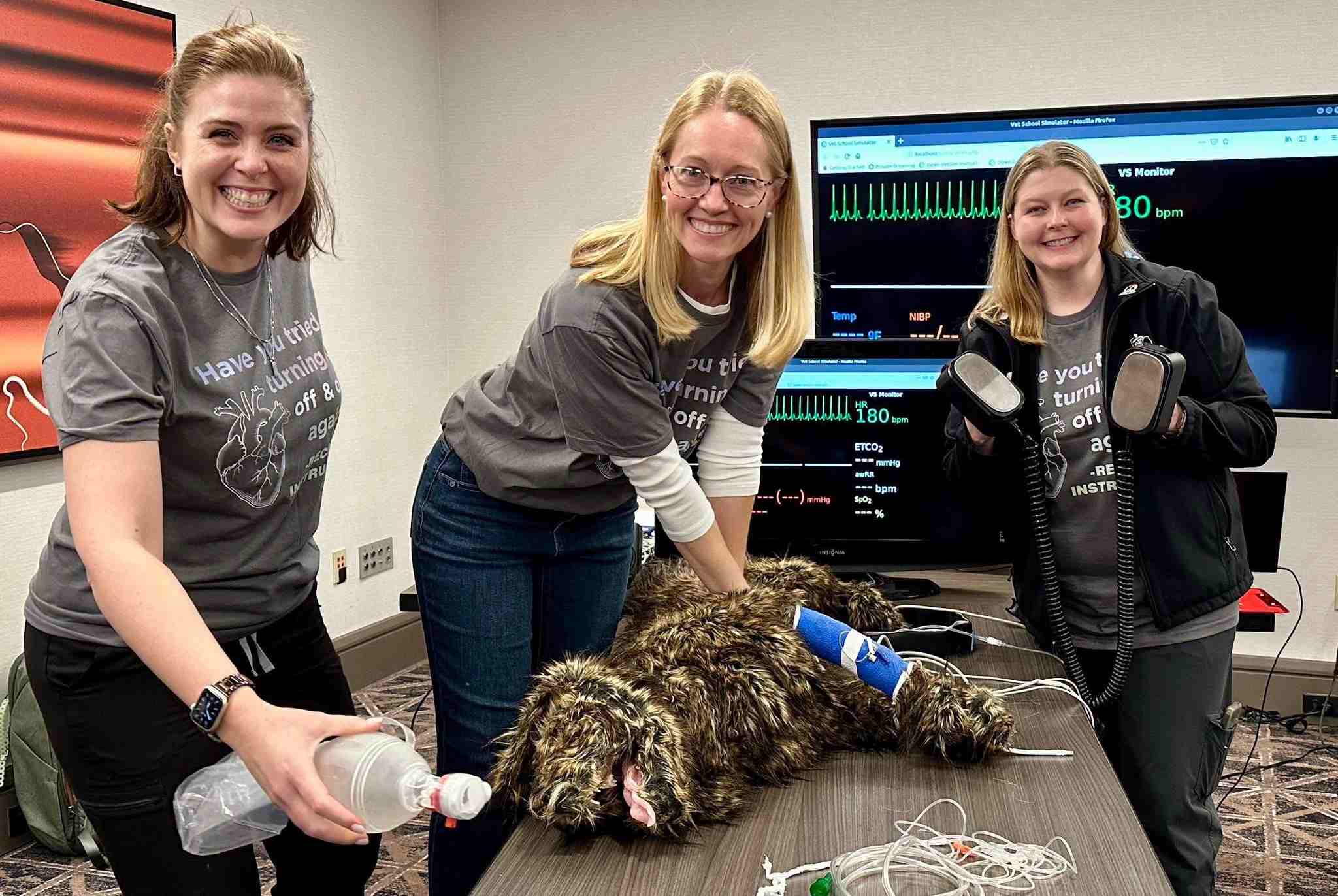 Staff members learning CPR with a dog mannequin.