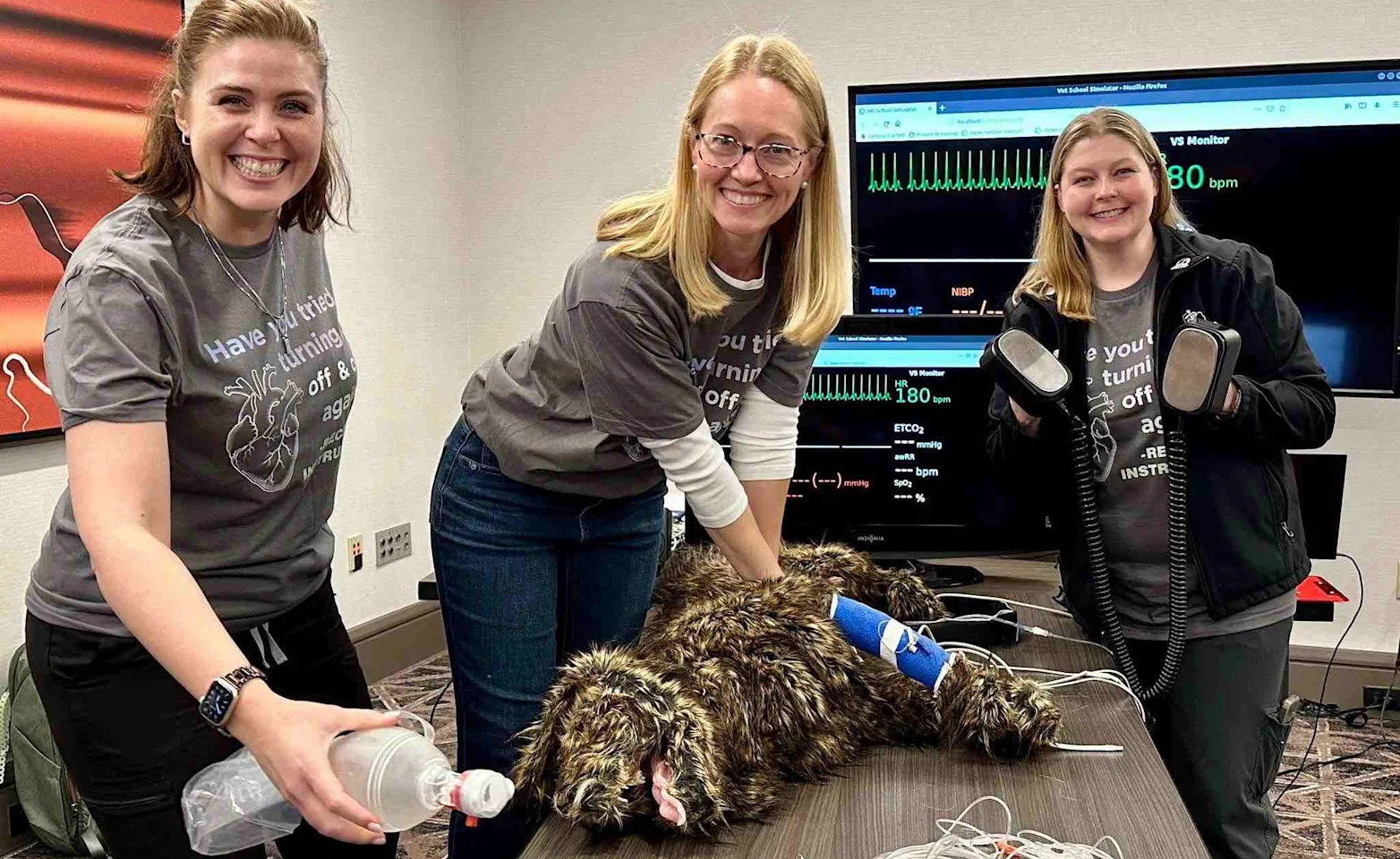 Staff members learning CPR with a dog mannequin. Staff members learning CPR with a dog mannequin.