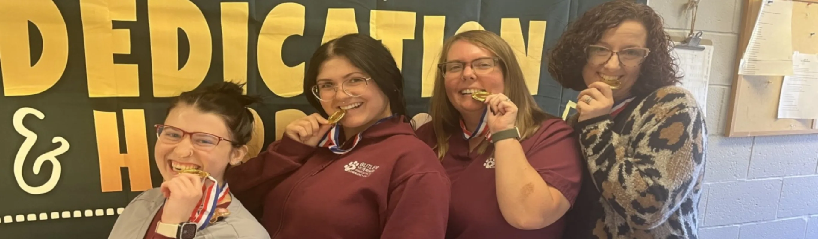 Contact Us photo of staff members posing with medals Contact Us photo of staff members posing with medals