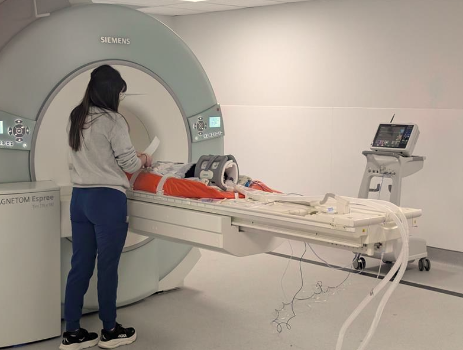 Staff standing next to an MRI machine.