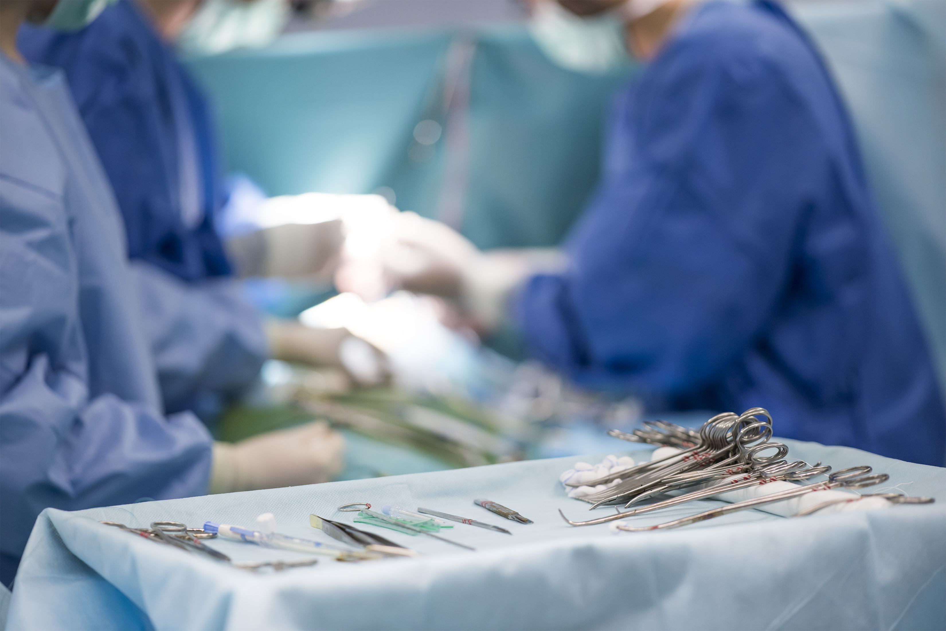 Doctors in surgery with surgery supplies sitting on a tray