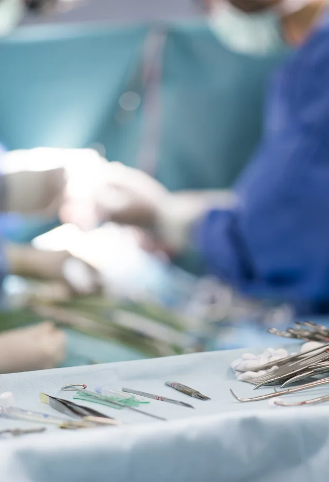 Doctors in surgery with surgery supplies sitting on a tray