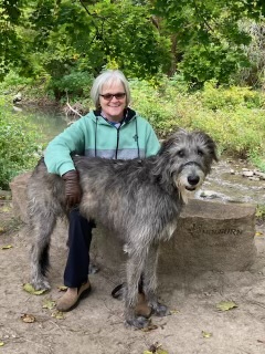 Sandra McBride in a nature setting with her Irish Wolfhound