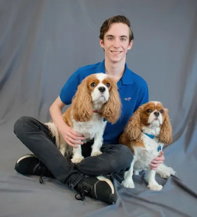 Matthew sitting with two dogs