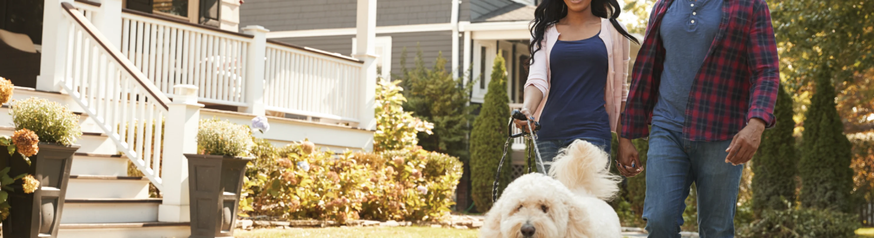 Family walking dog out in front of house