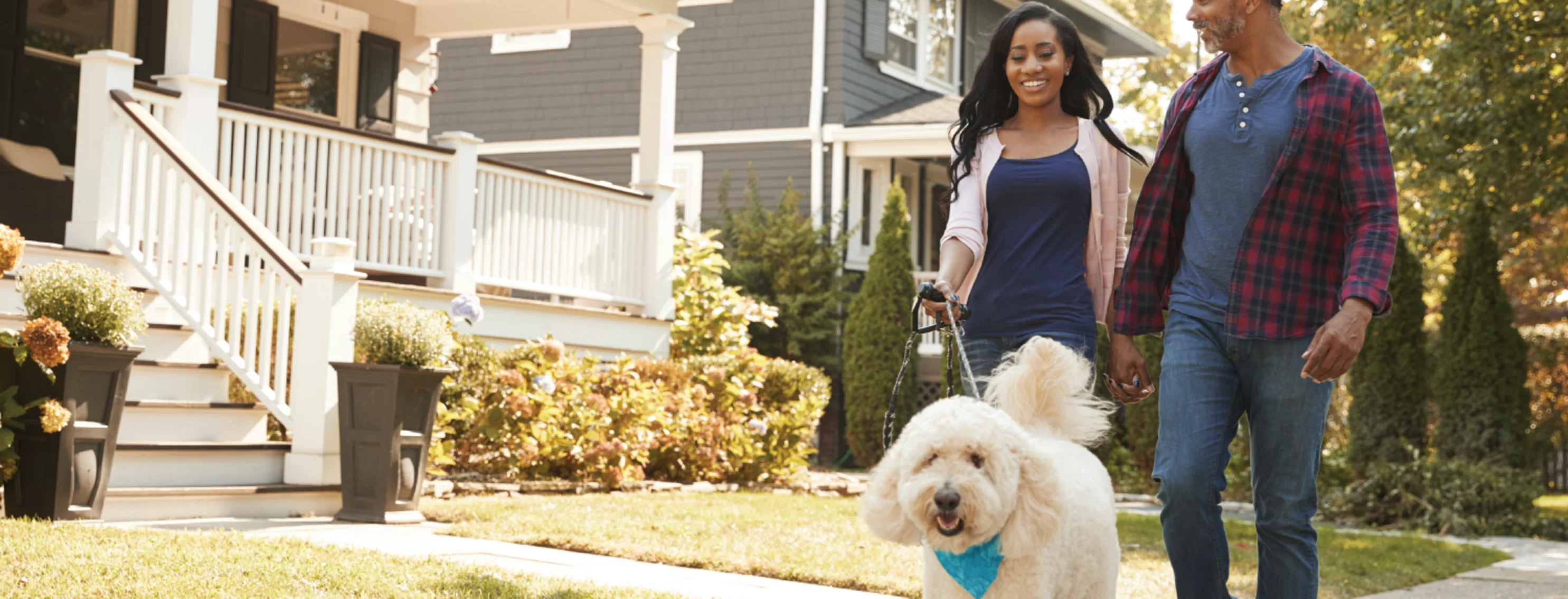 Family walking dog out in front of house