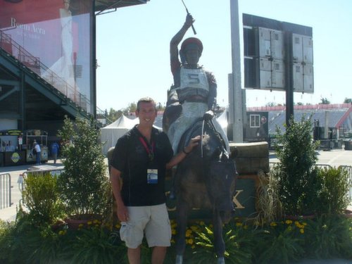 Dr. Browning with statue of a jockey at a racetrack